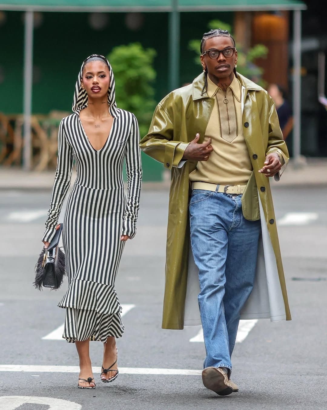 A striped hooded midi dress is paired beside an olive glossy trench, beige polo, blue jeans, and neutral accessories.